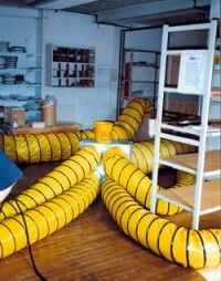 Heat Treatment in progress at a commercial food handling plant Heat exchangers and insulated pipes in a room.